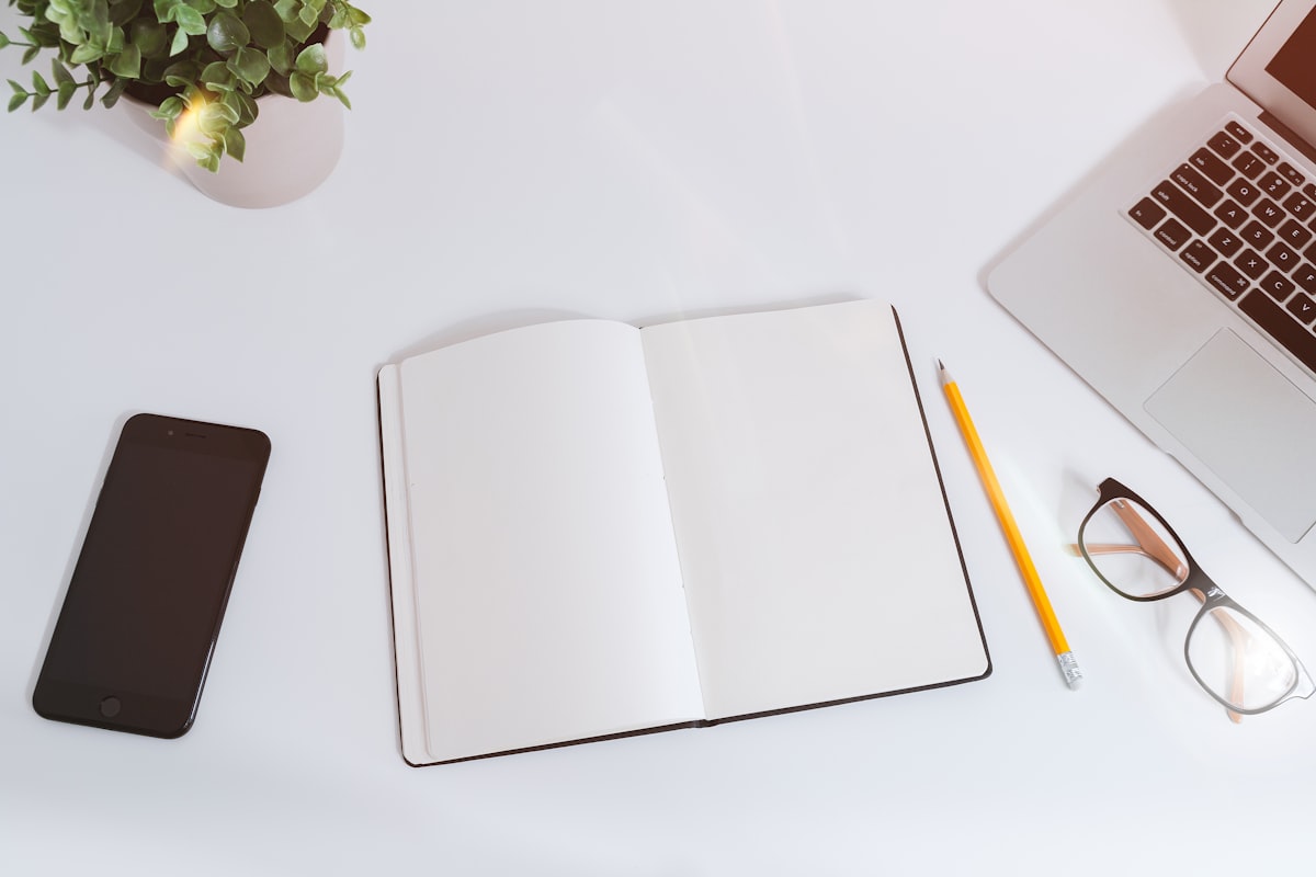 Mesa de trabajo con currículum y portátil