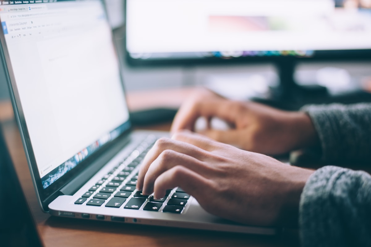 Scrivania con laptop aperto e documenti — esempi di lettera motivazionale